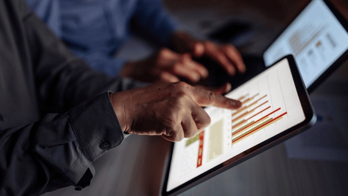 People looking over graphs in tablet