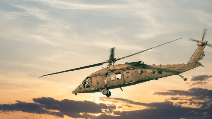 A United States military helicopter flying over a tactical zone on a defense transport mission