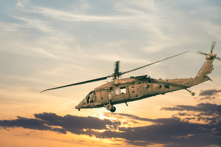 A United States military helicopter flying over a tactical zone on a defense transport mission