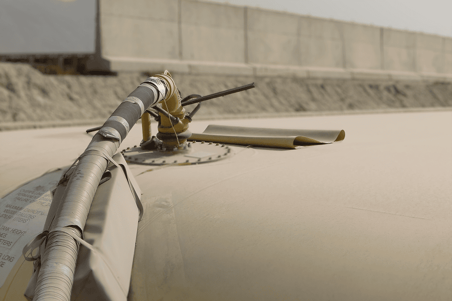 Industrial storage tank with monitoring equipment and piping installed along the top surface.