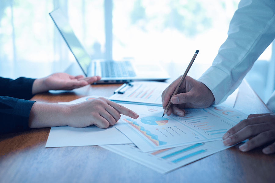 Hands discussing financial reports and charts.