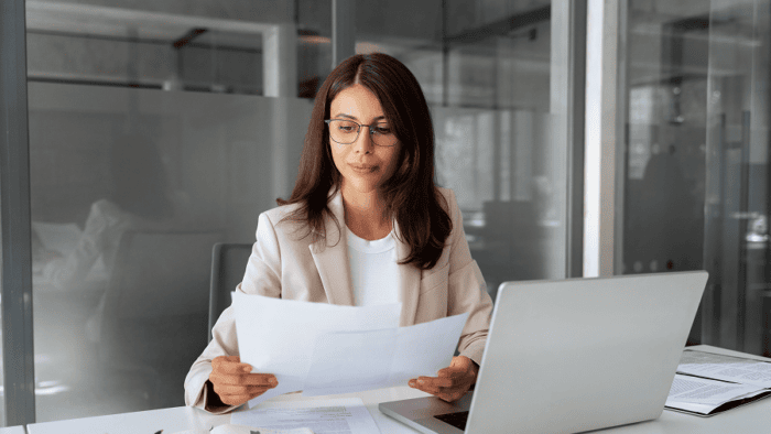 Woman reviewing documents at desk.
