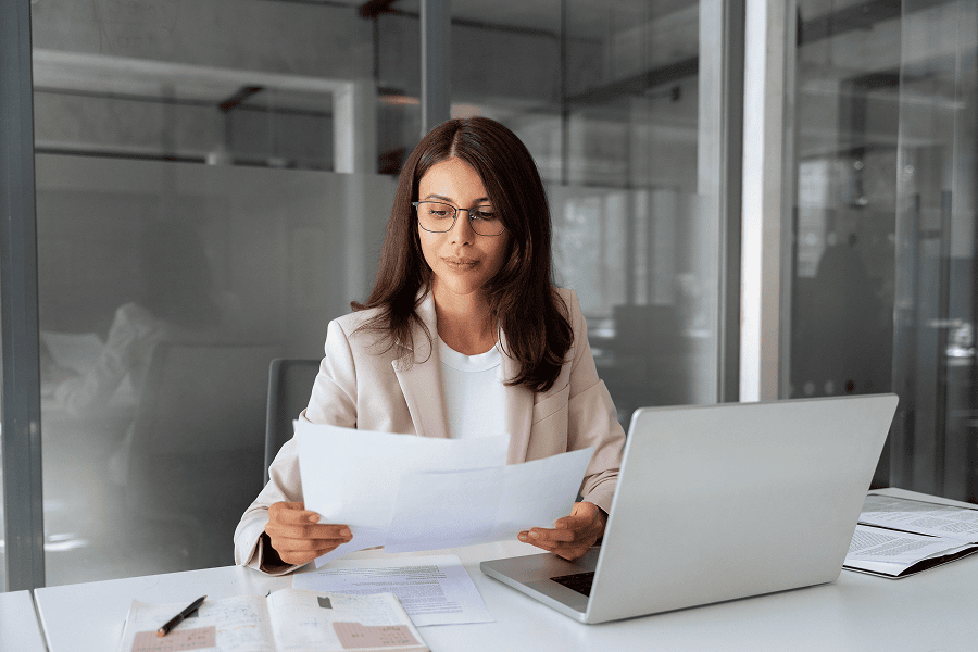 Woman reviewing documents at desk.