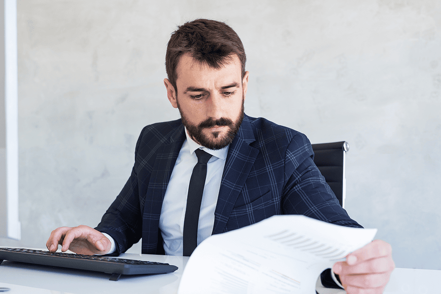 Man reviewing documents at desk.