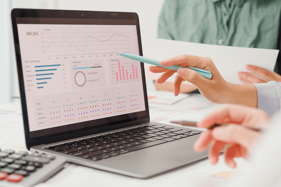 People looking over charts in laptop screen
