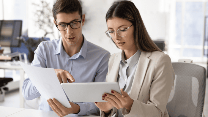 Business discussion with documents and tablet.