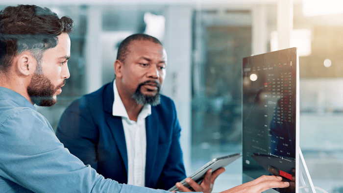 Two men discussing business statistics together.