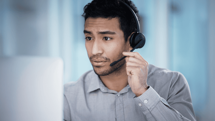 Man with headset looking at computer screen