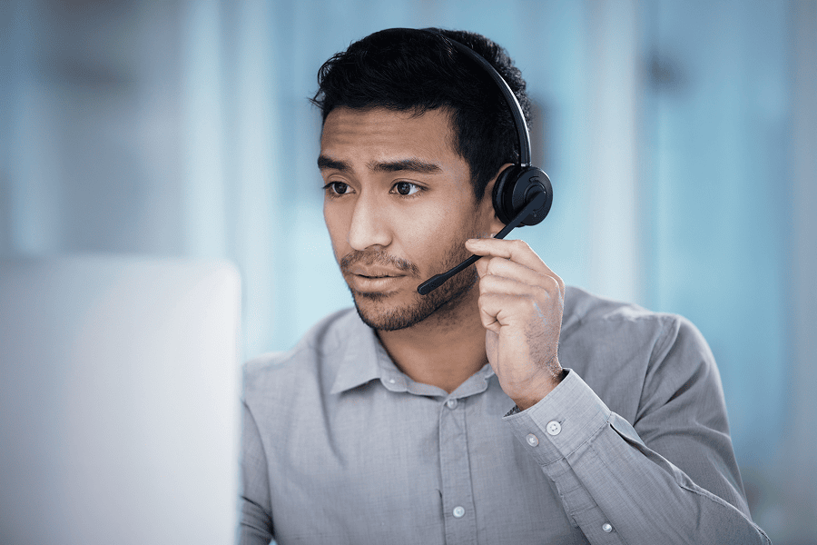 Man with headset looking at computer screen