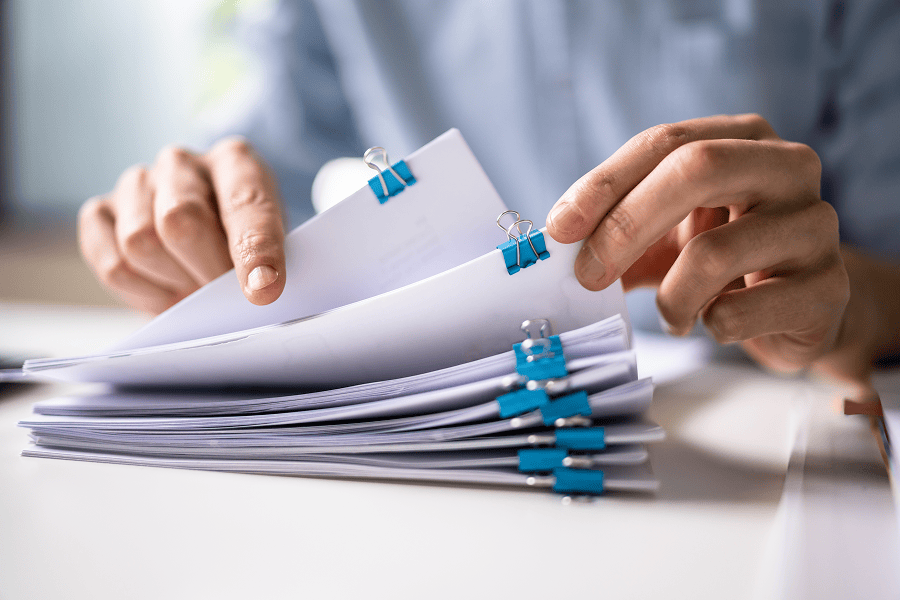 Person organising documents with clips.