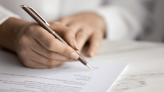 Woman signing documents with pen.