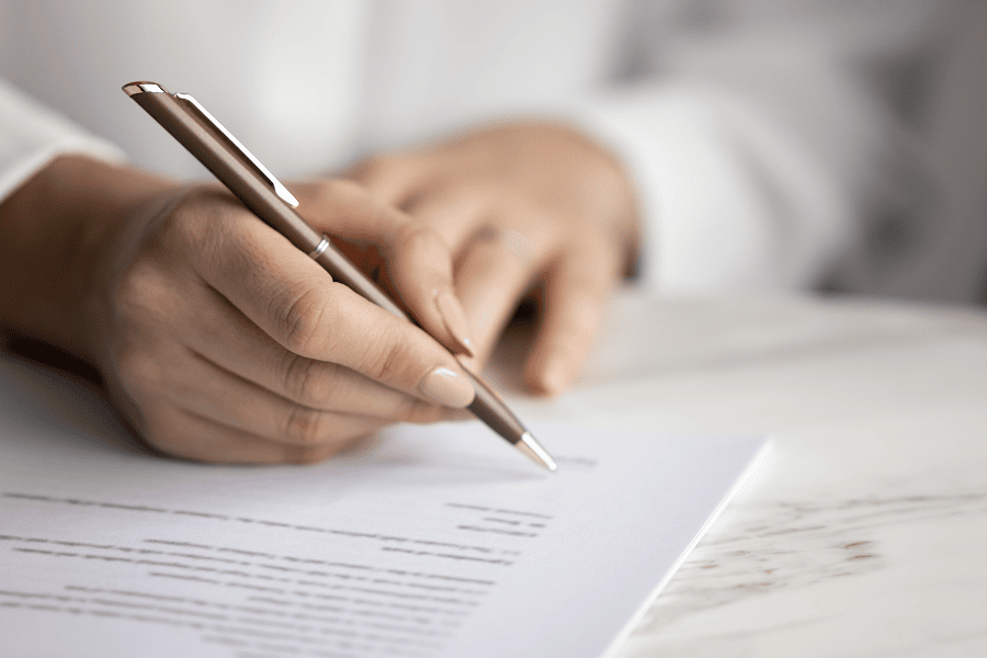 Woman signing documents with pen.