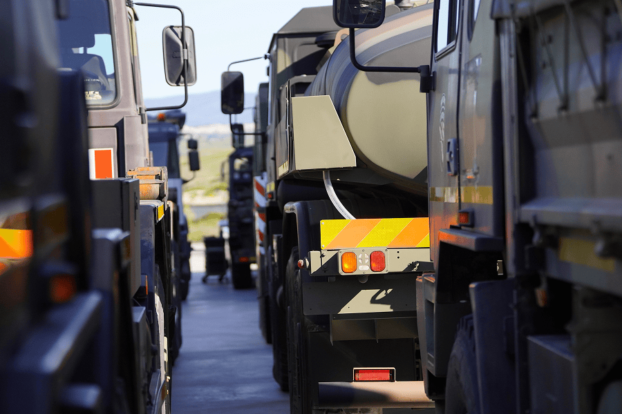 A detailed close-up of heavy logistics vehicles and tactical fuel tankers parked at a defense supply facility