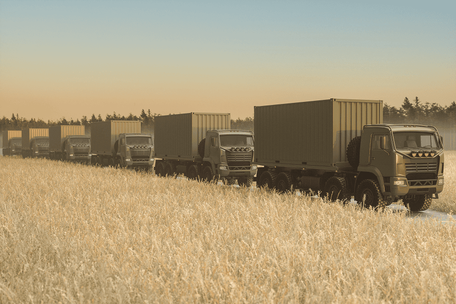 A close-up view of a military motorcade convoy driving on an open road