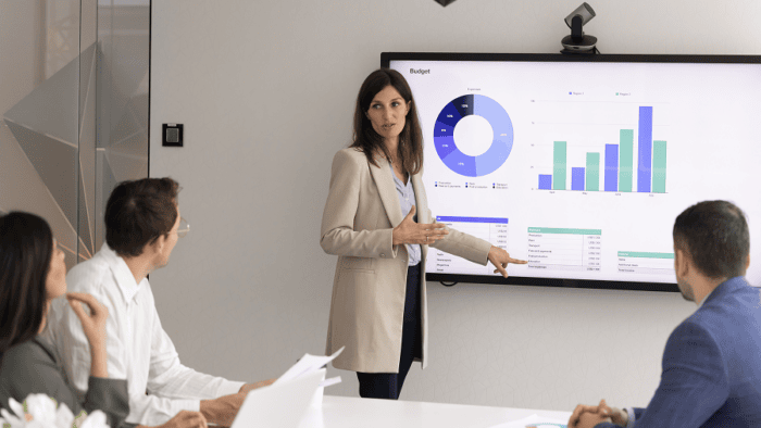 Woman presenting charts to group of people