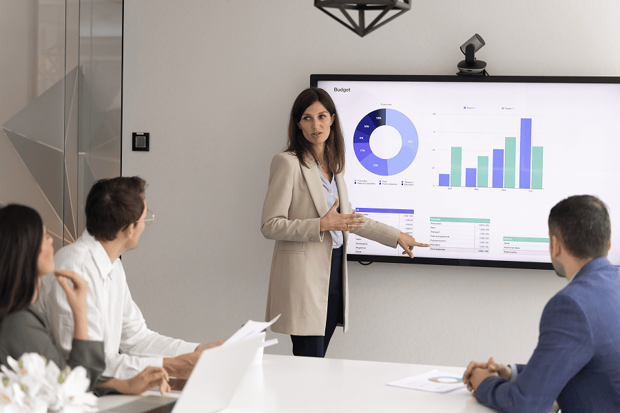 Woman presenting charts to group of people