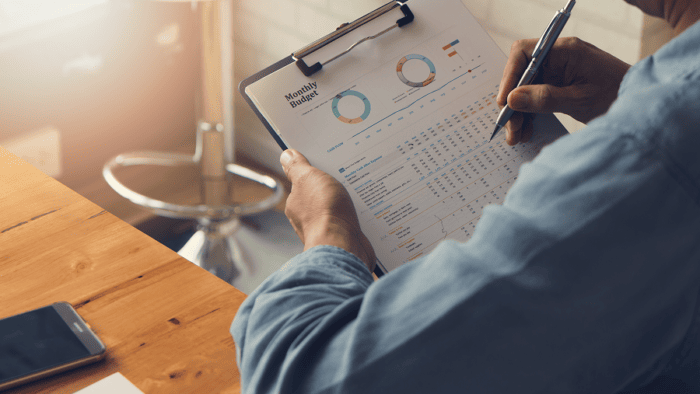 man with clipboard looking at monthly budget