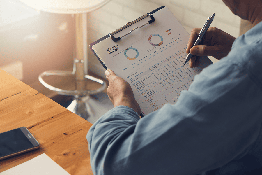 man with clipboard looking at monthly budget