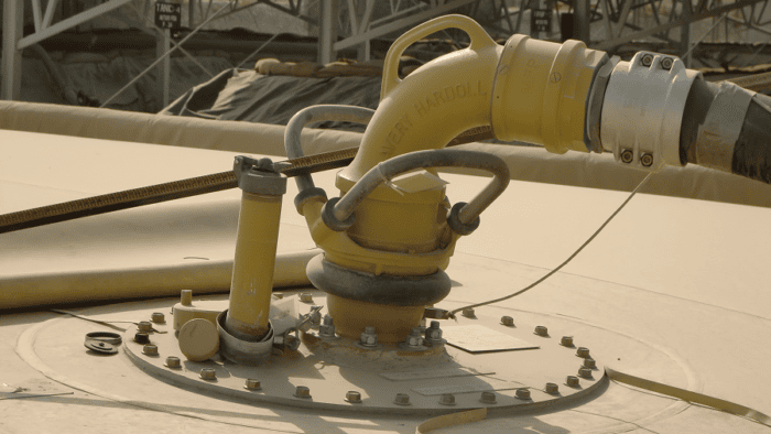 A fuel tank being refueled via an industrial pipeline