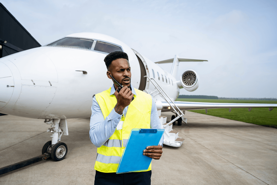 Ground crew member communicating near jet.