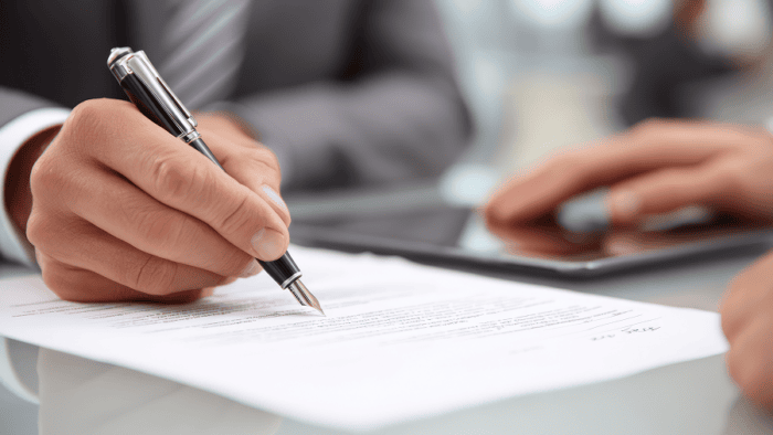 hand holding pen about to sign a document