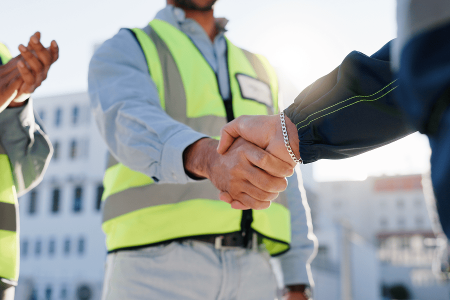 Two people shaking hands outdoors.