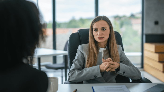 A human resource professional collaborating on recruitment strategies with a colleague in a corporate office setting.