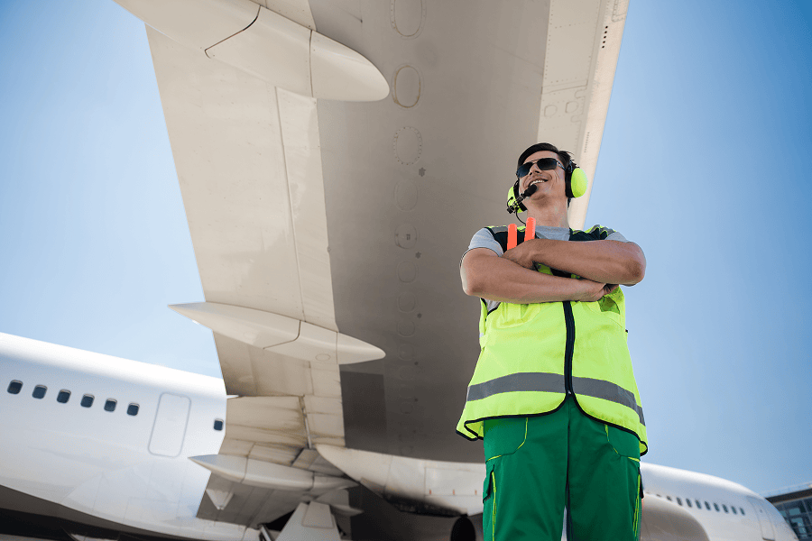 Man in safety gear under airplane wing