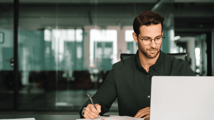 Man working on laptop in office.