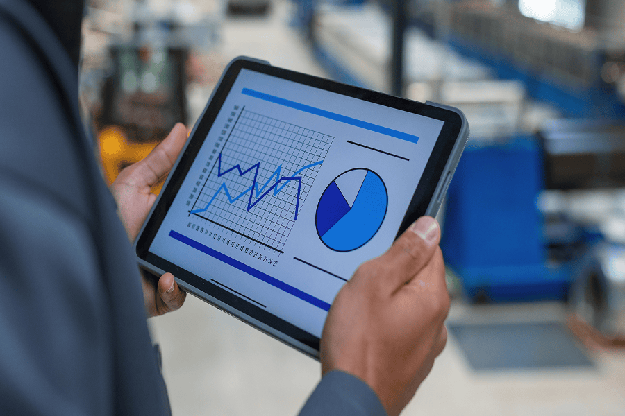 person holding tablet with reports on screen