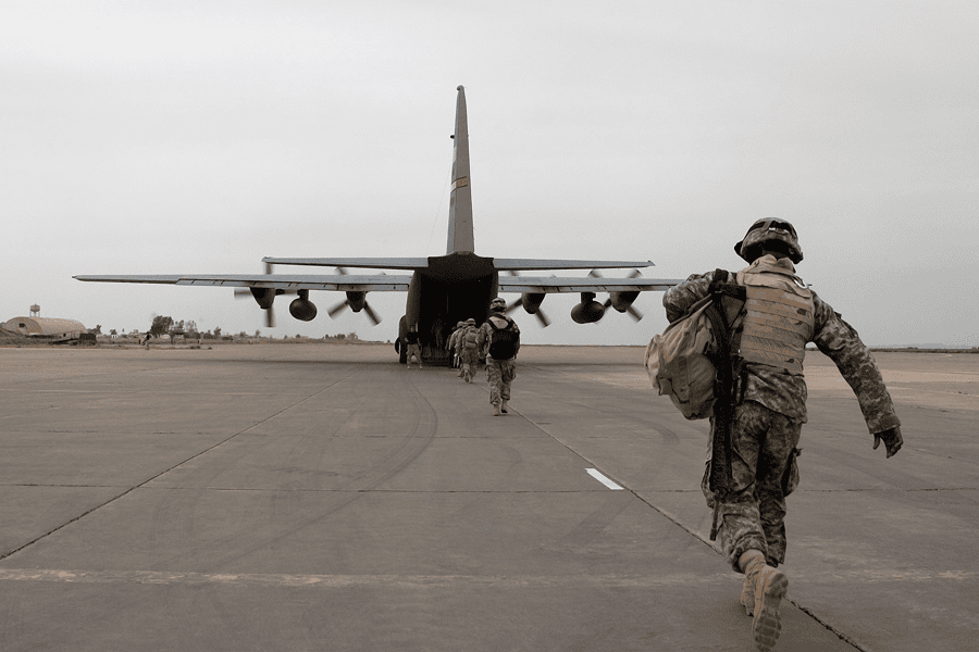 A large military aircraft loading up equipment and tactical supplies on an airfield tarmac