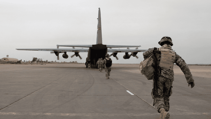 A large military aircraft loading up equipment and tactical supplies on an airfield tarmac