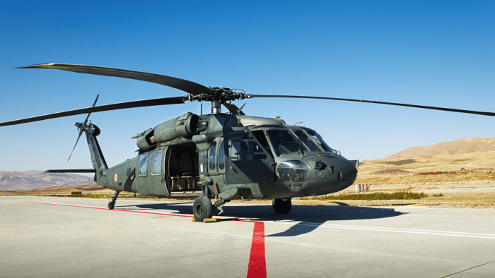 A military helicopter parked on an airfield landing pad