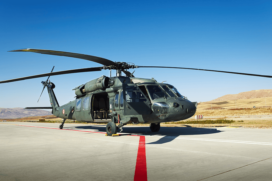 A military helicopter parked on an airfield landing pad