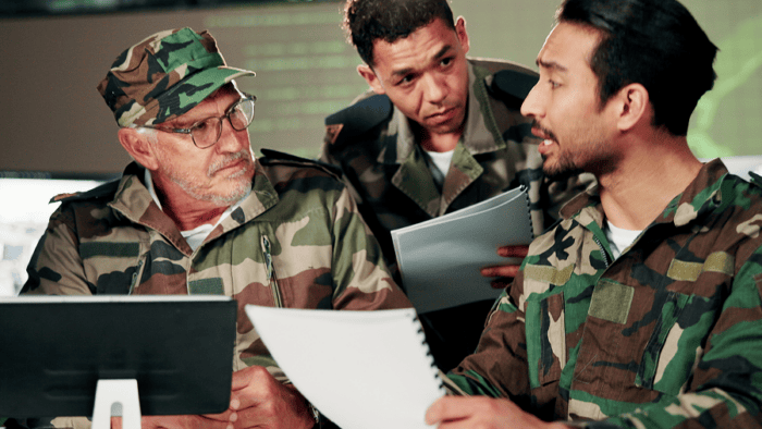 A military leadership team holding a strategic briefing with paperwork