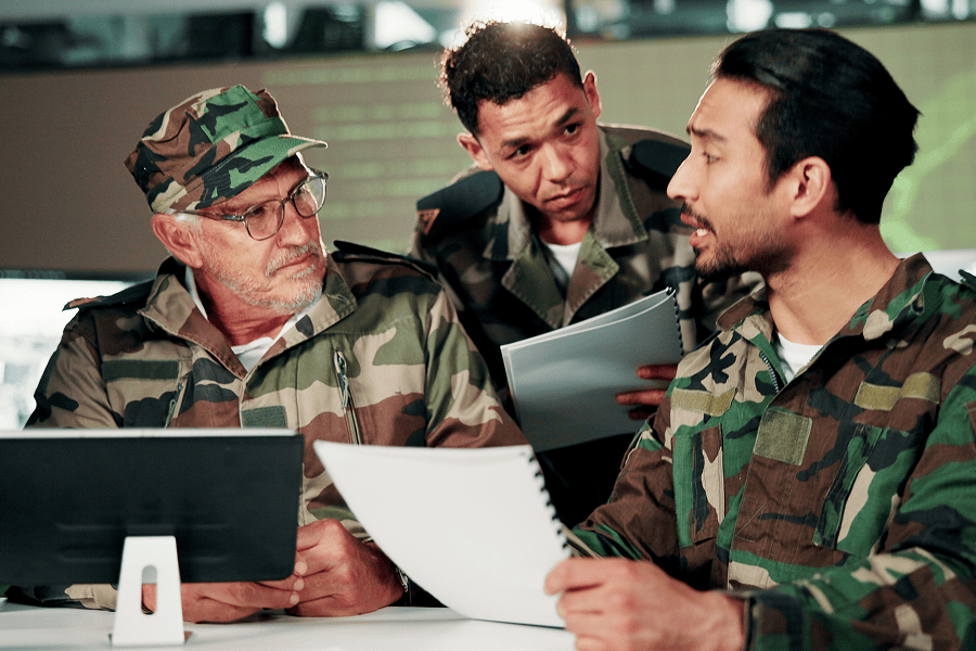 A military leadership team holding a strategic briefing with paperwork