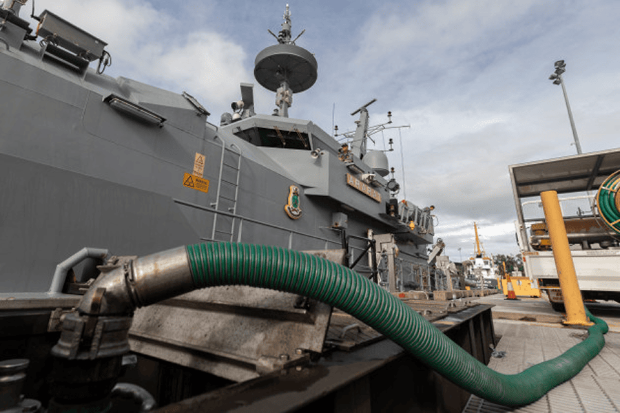 A naval ship undergoing military refueling operations at sea to maintain maritime defense readiness