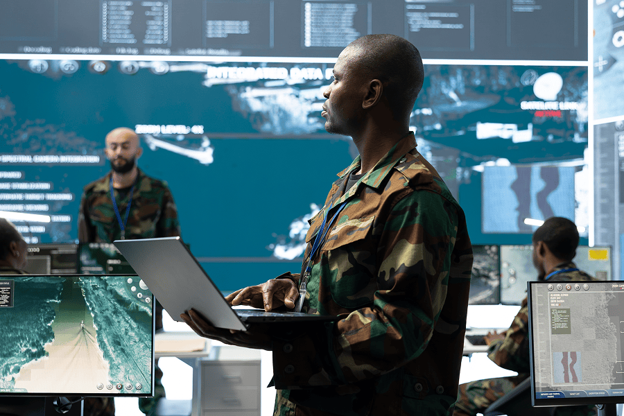 A military specialist holding an open laptop during command operations