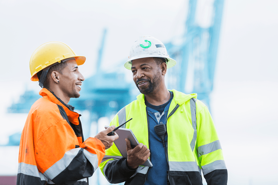 A team of multi-ethnic men working at a shipping port terminal