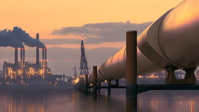 Pipeline beside factories at sunset.