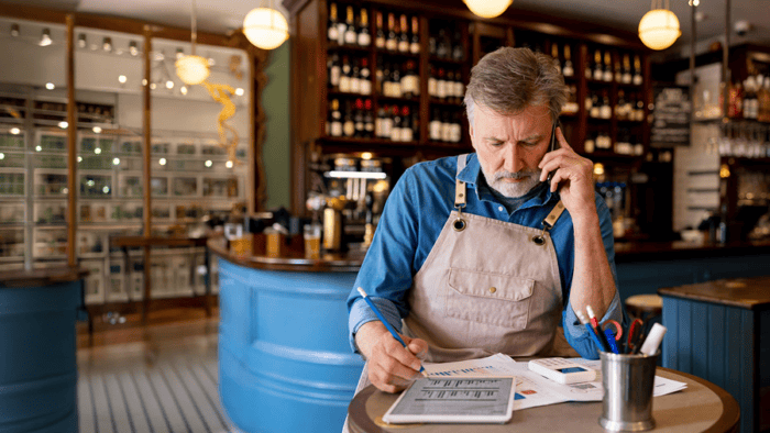 Man analysing charts while on phone.