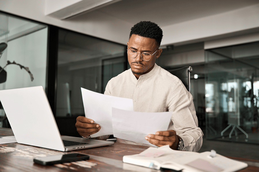 Man reviewing documents at desk.