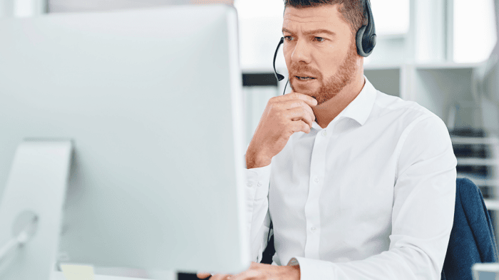 A serious young male customer service representative wearing a headset