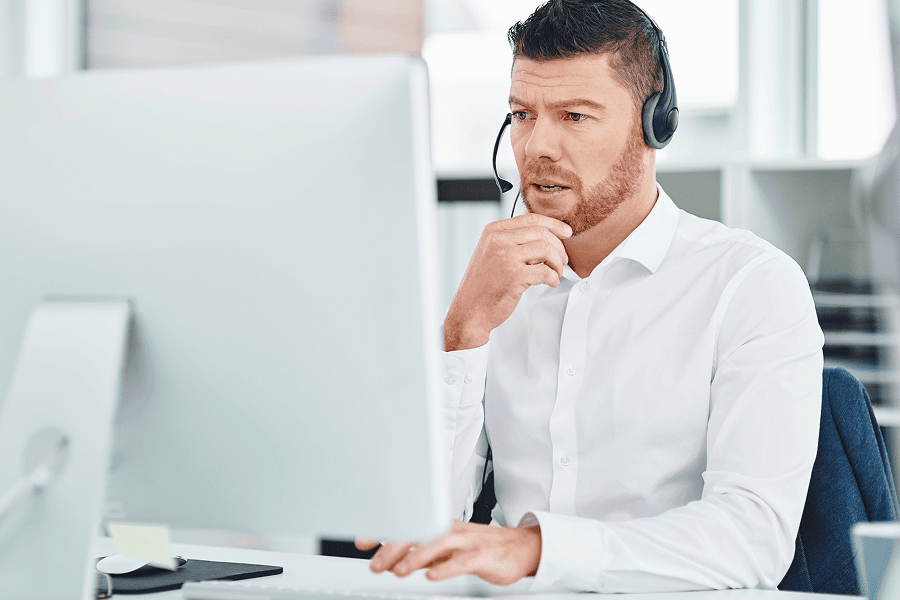 A serious young male customer service representative wearing a headset