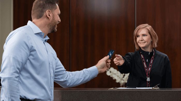 Man handing card to receptionist