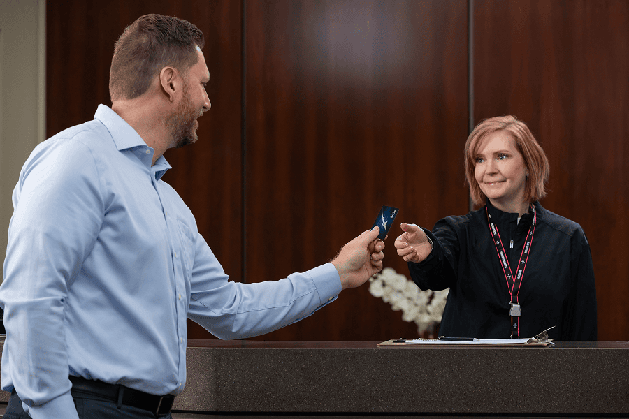 Man handing card to receptionist