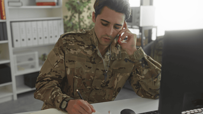 A military soldier in uniform with a phone