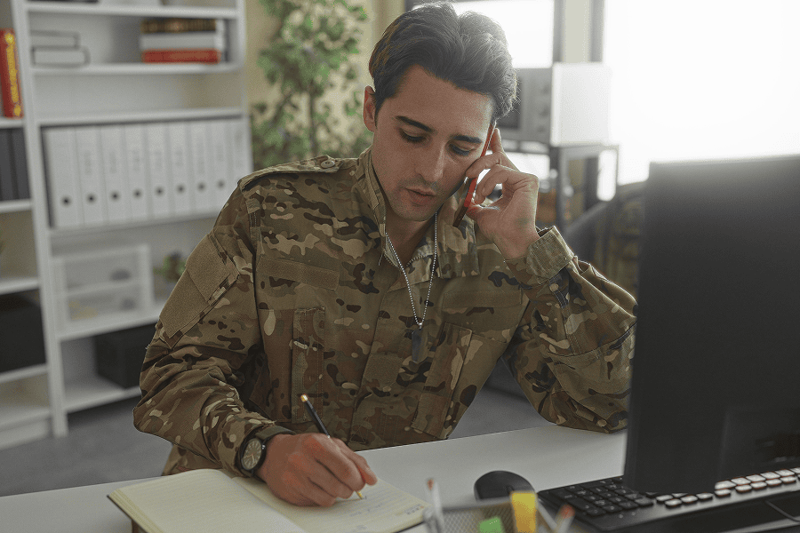 A military soldier in uniform with a phone