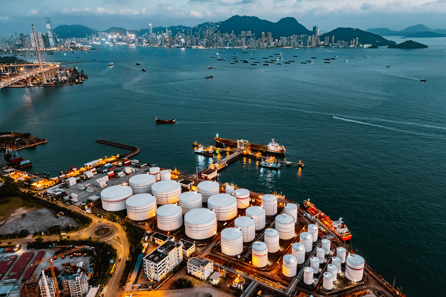 A maritime tank ship loading and unloading oil and gasoline at a commercial dock facility
