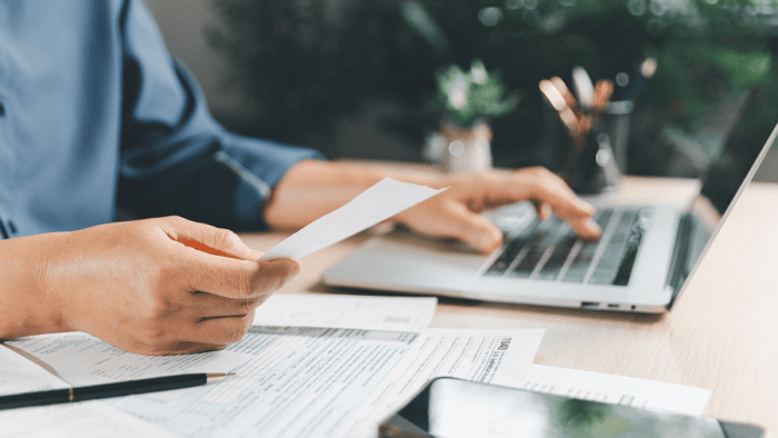 man holding paper while typing